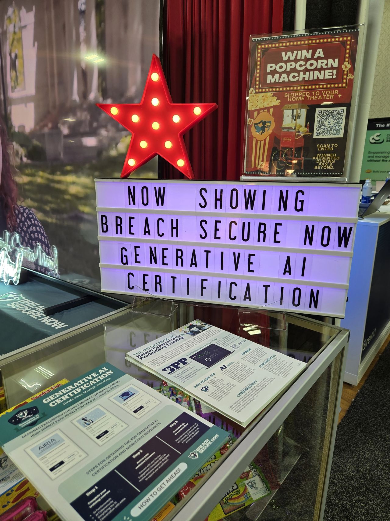 A cinema marquee at the Breach Secure Now booth, Pax8 Beyond 2025, reading Now Showing, Generative AI Certification
