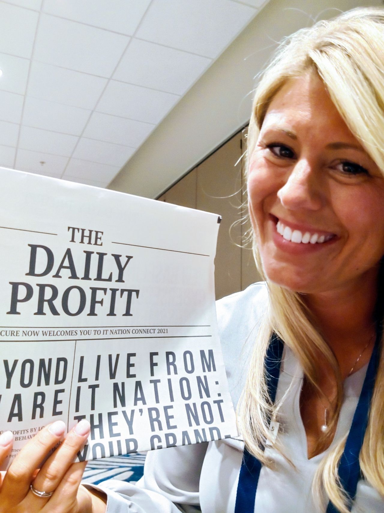 Tracie Crites holding The Daily Profit, a Breach Secure Now newspaper handout welcoming attendees to IT Nation Connect 2021